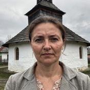 Guide Nadiia Stets by a wooden church in Bukovyna